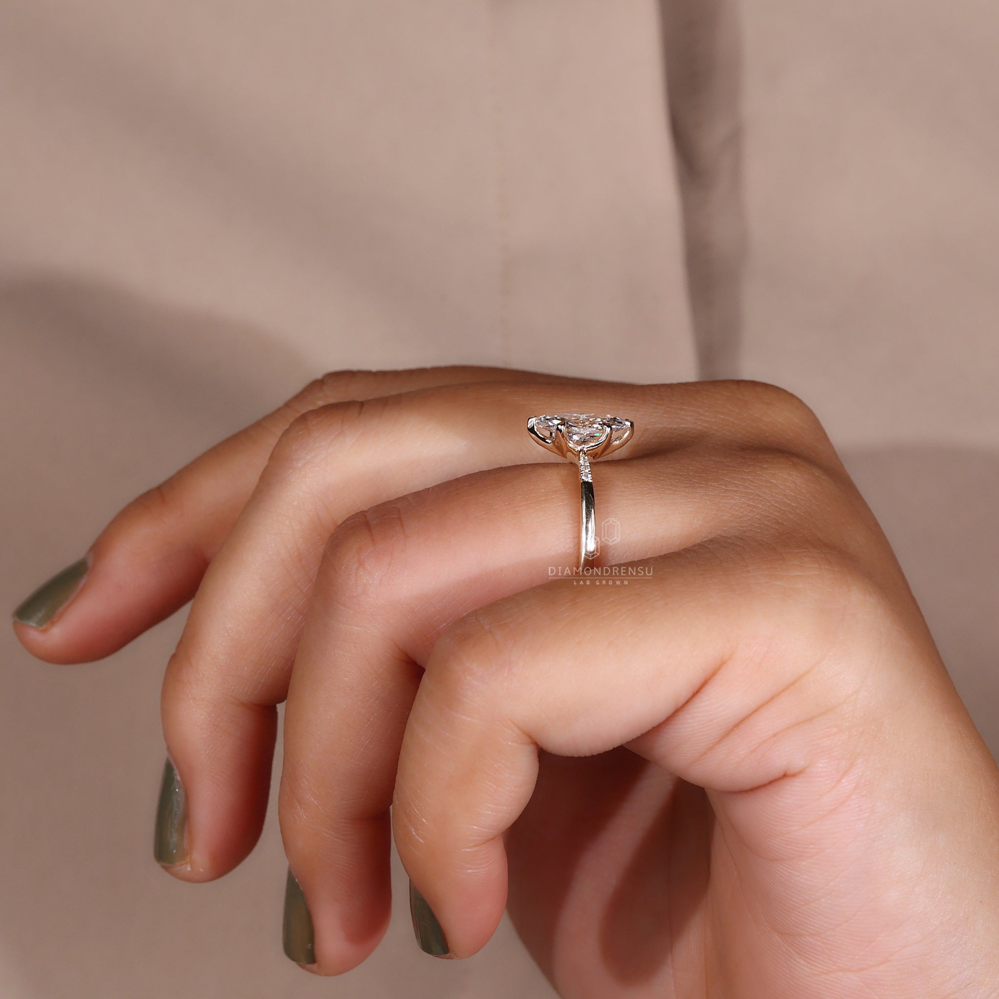 Side view of a marquise diamond ring featuring claw prongs and a yellow gold setting.