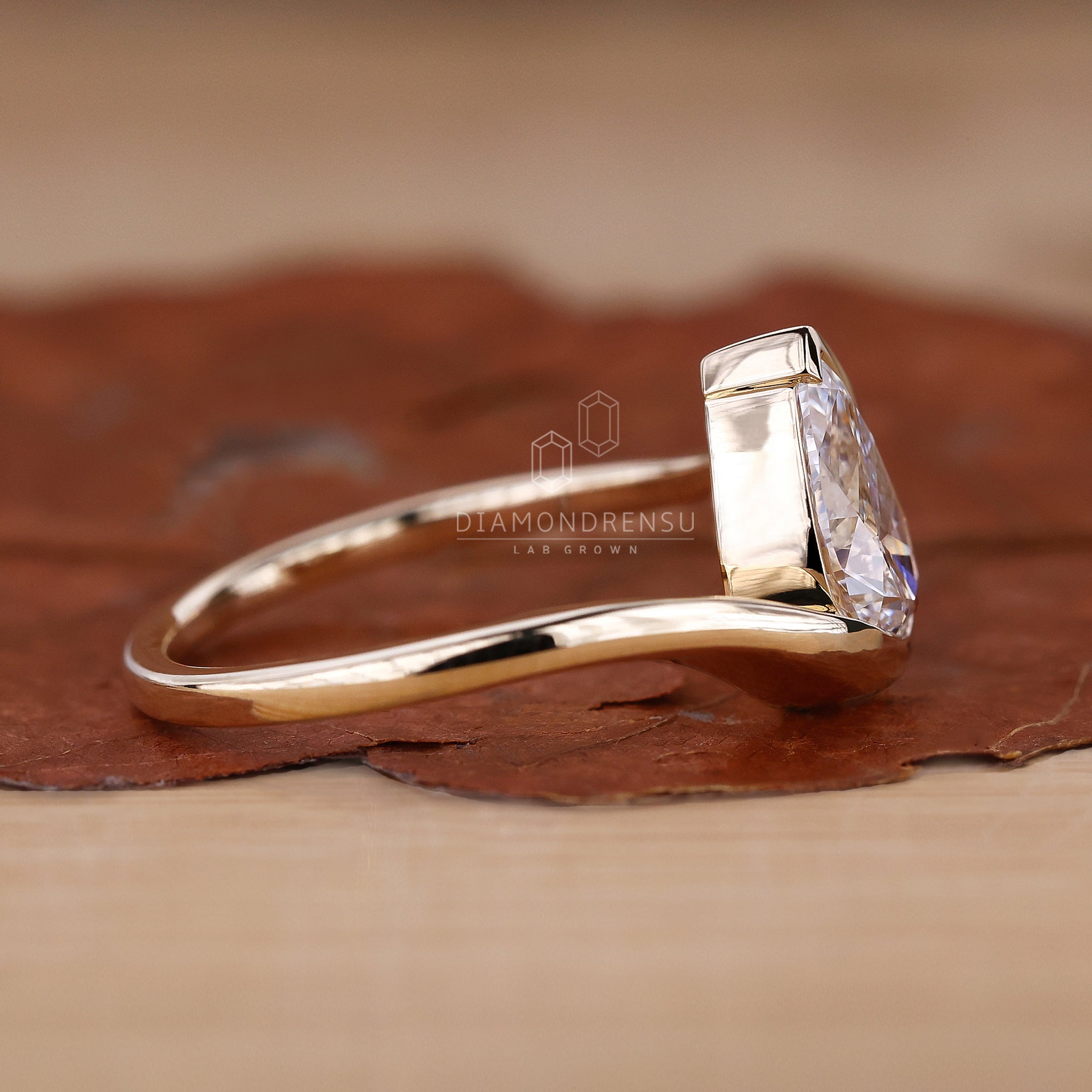 Unique design handmade ring in yellow gold featuring a pear shaped diamond