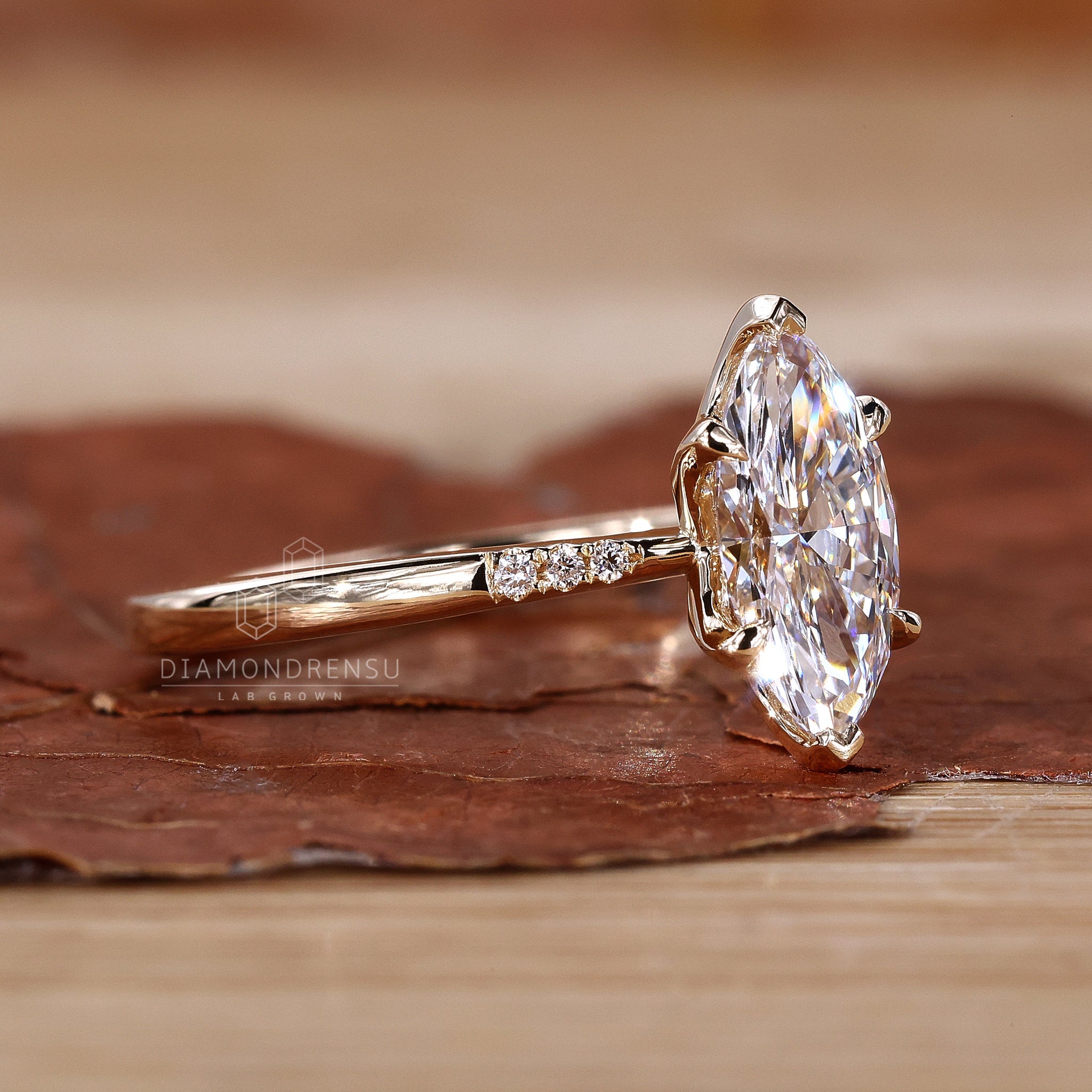 Detailed view of a marquise diamond ring with claw prongs, set in a classic yellow gold band.