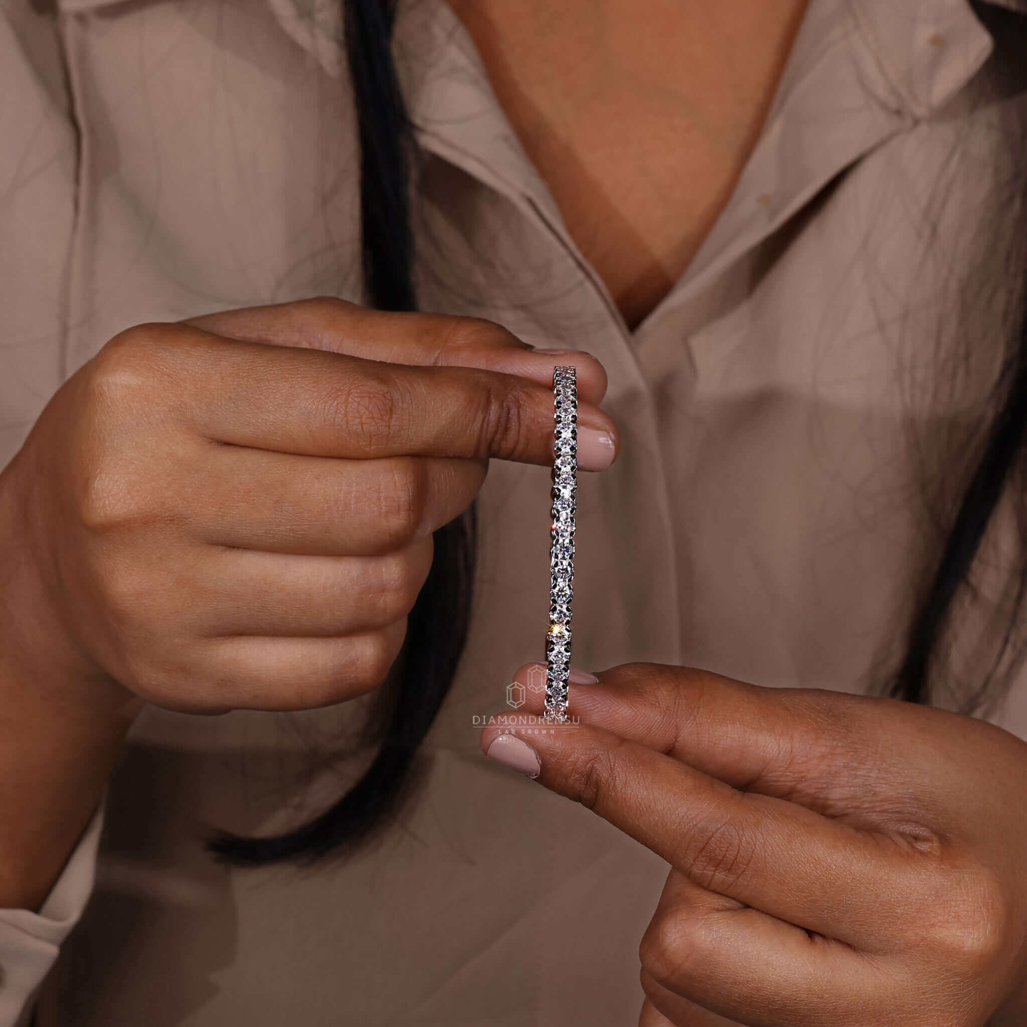 Model wearing a tennis bangle bracelet with round lab-grown diamonds