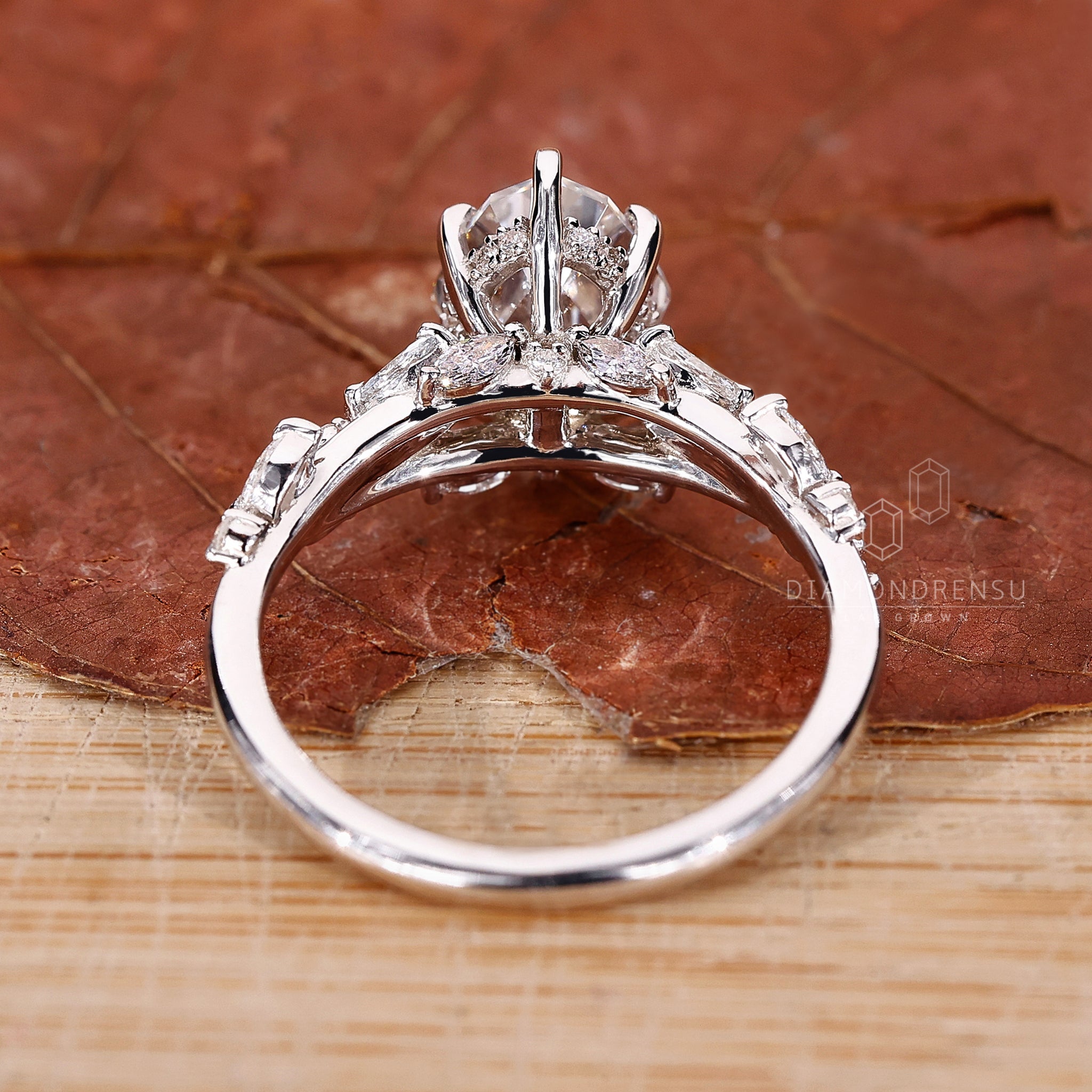 Lab grown diamond oval engagement ring with IGI certified step cut diamond, displayed on a natural background.