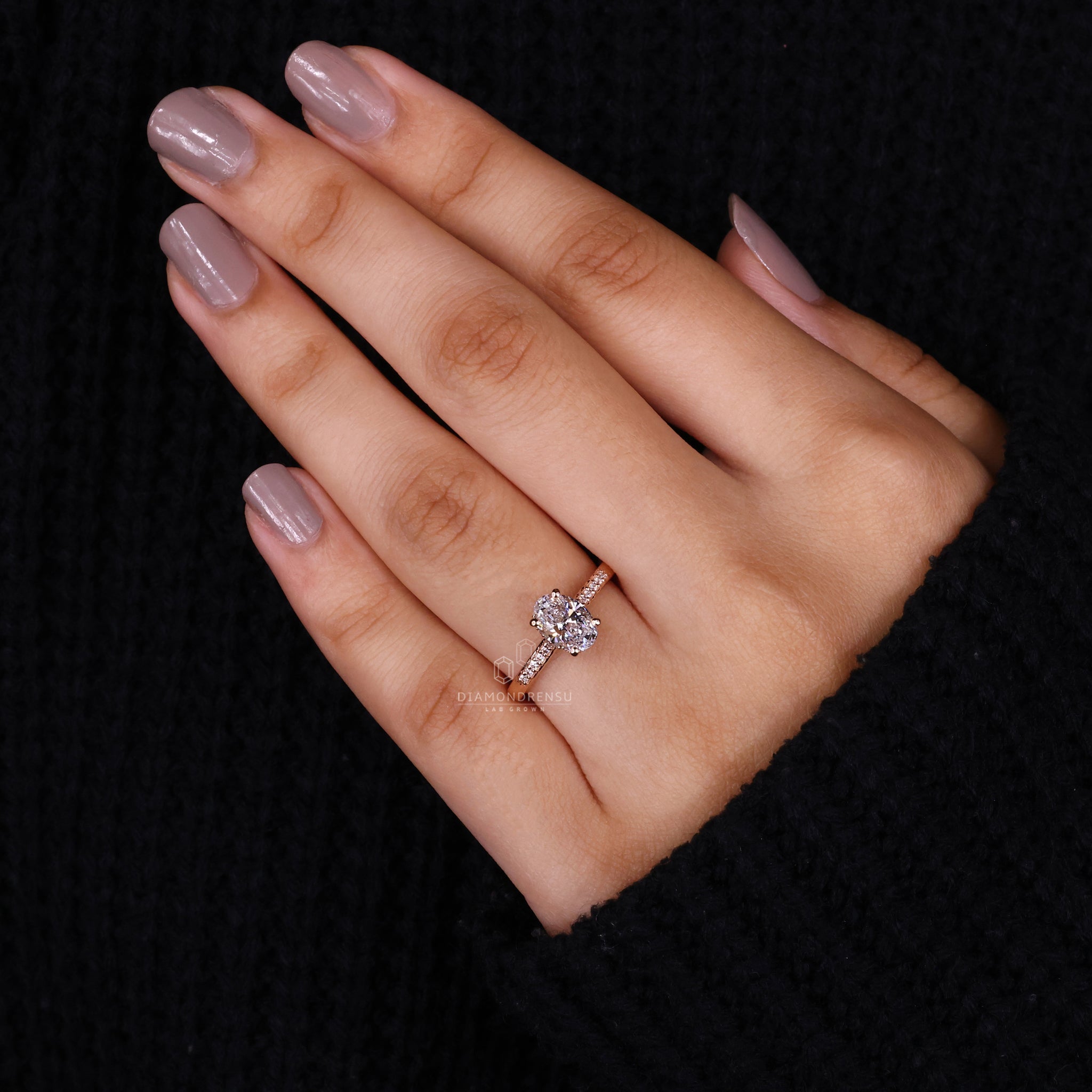 Model wearing an oval lab grown diamond engagement ring with a hidden halo, showcasing the brilliance of the oval cut diamond.