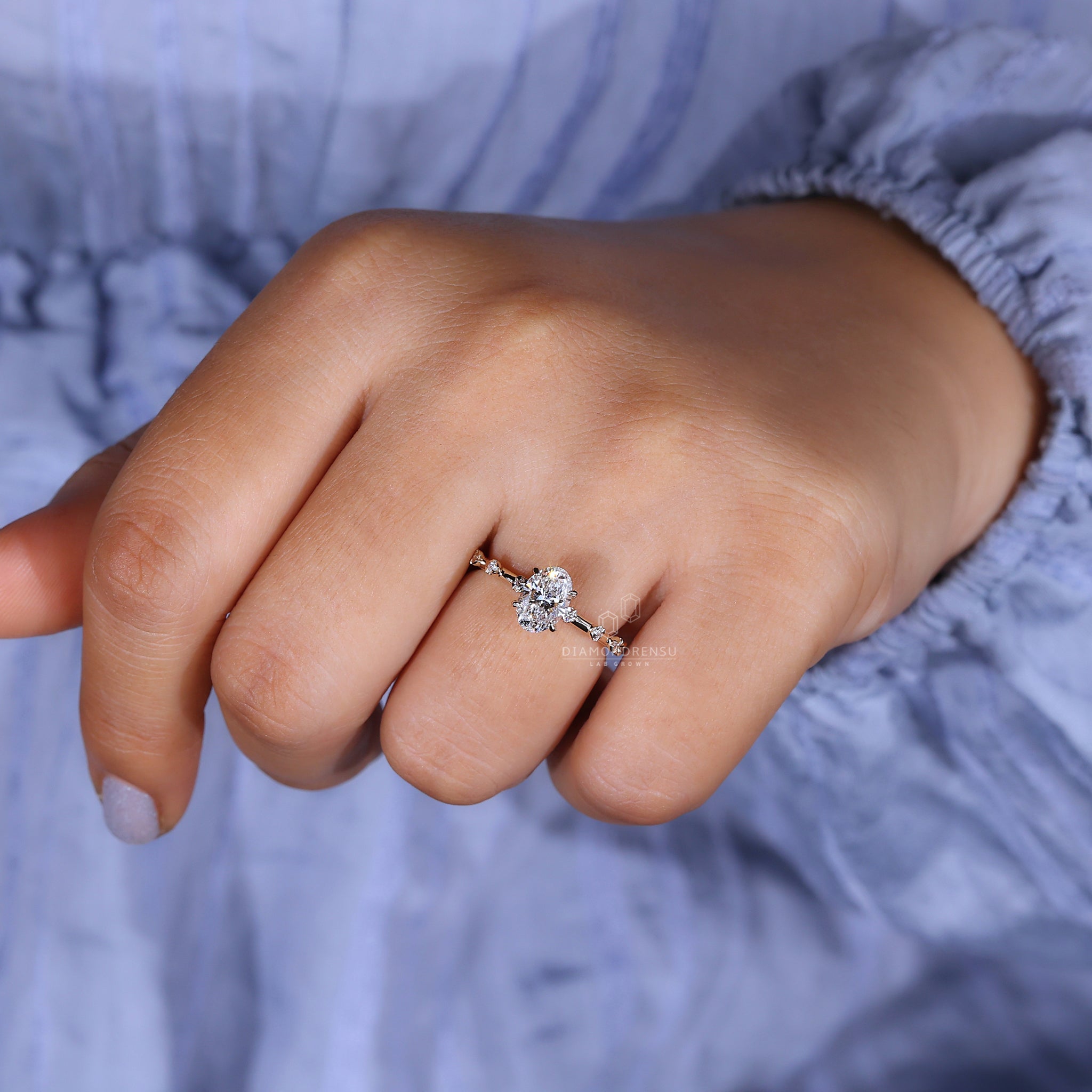 Woman wearing an oval diamond engagement ring with hidden halo, featuring a lab grown diamond.