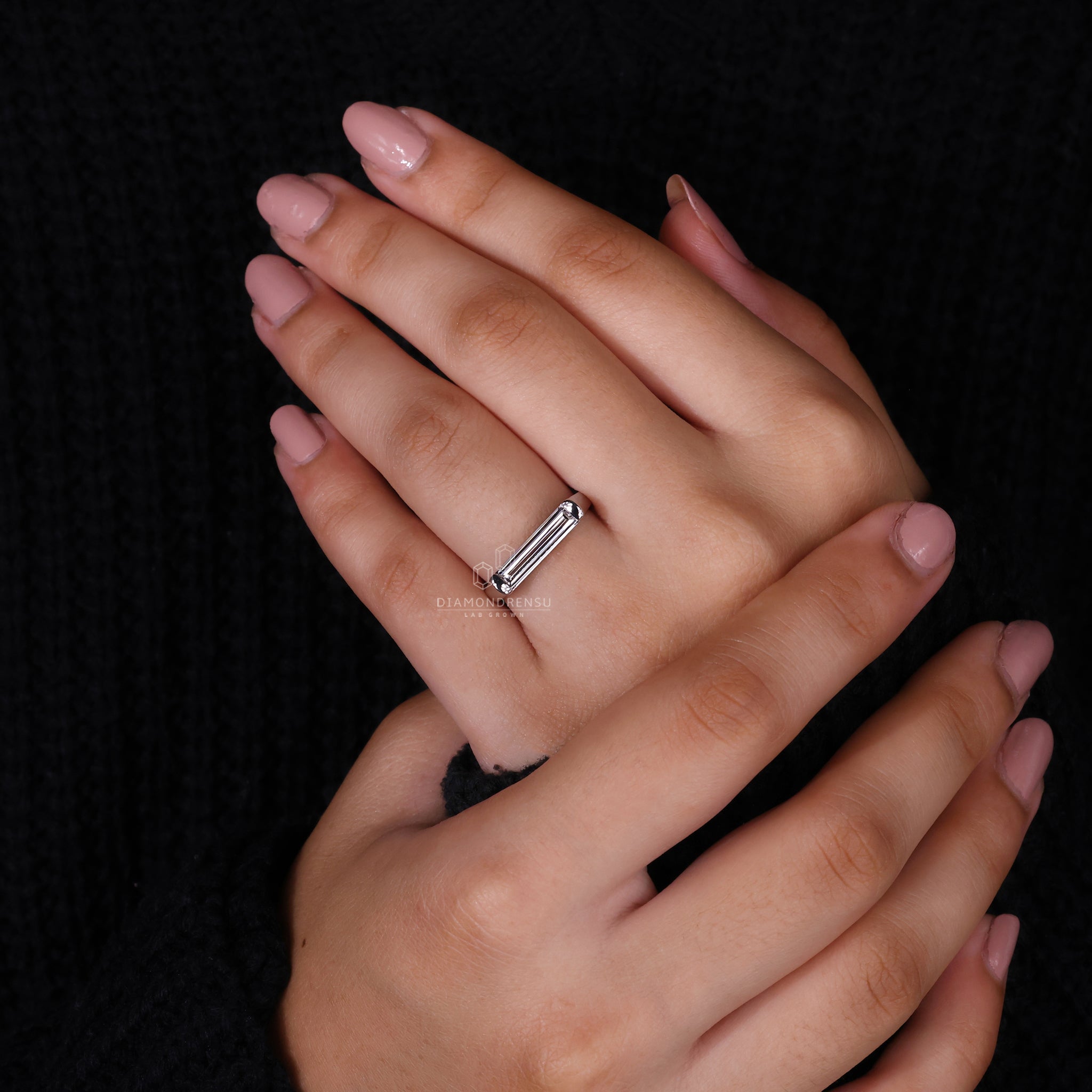 White gold ring with baguette diamond on model’s finger