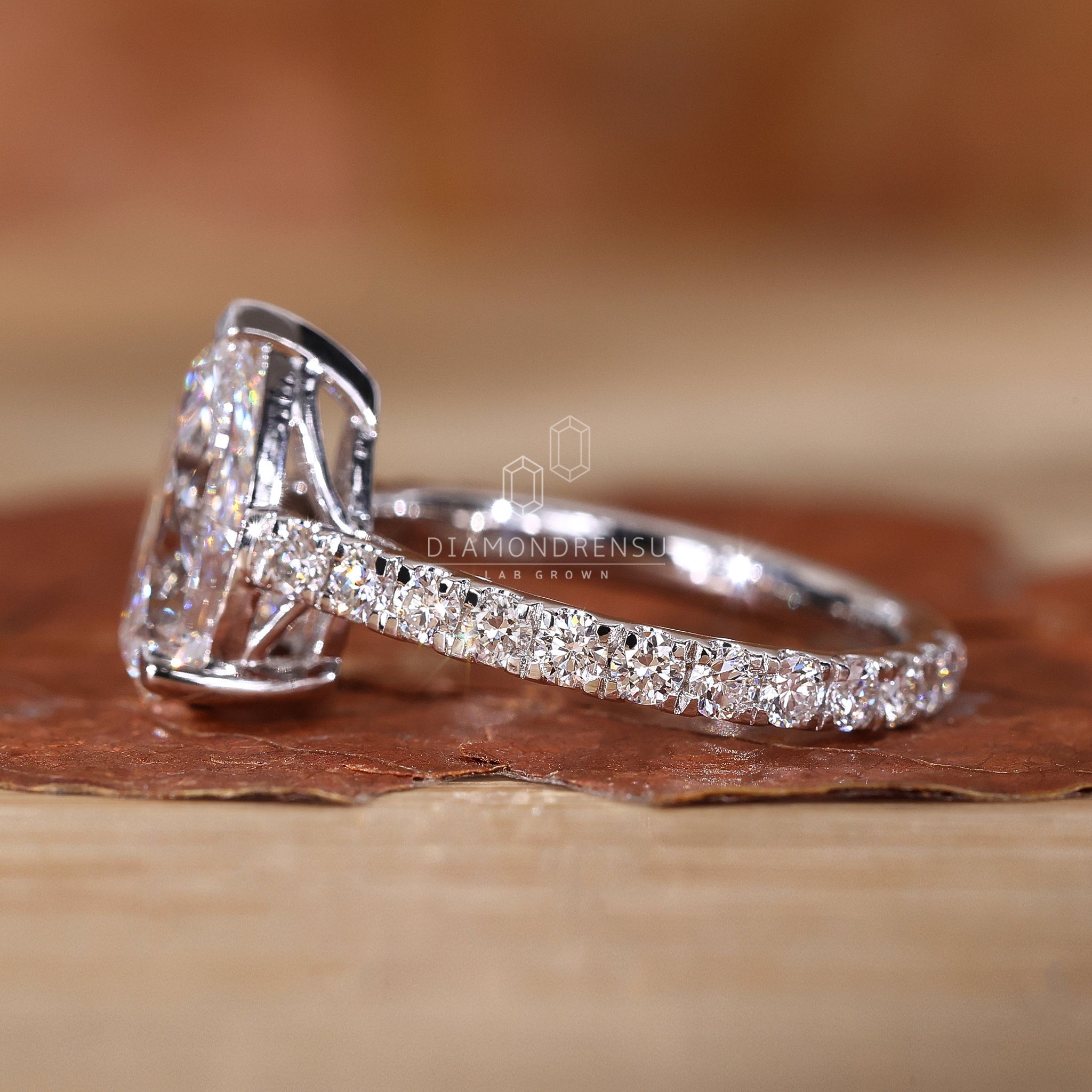 Detailed view of a pear shaped diamond ring with pave diamond detailing