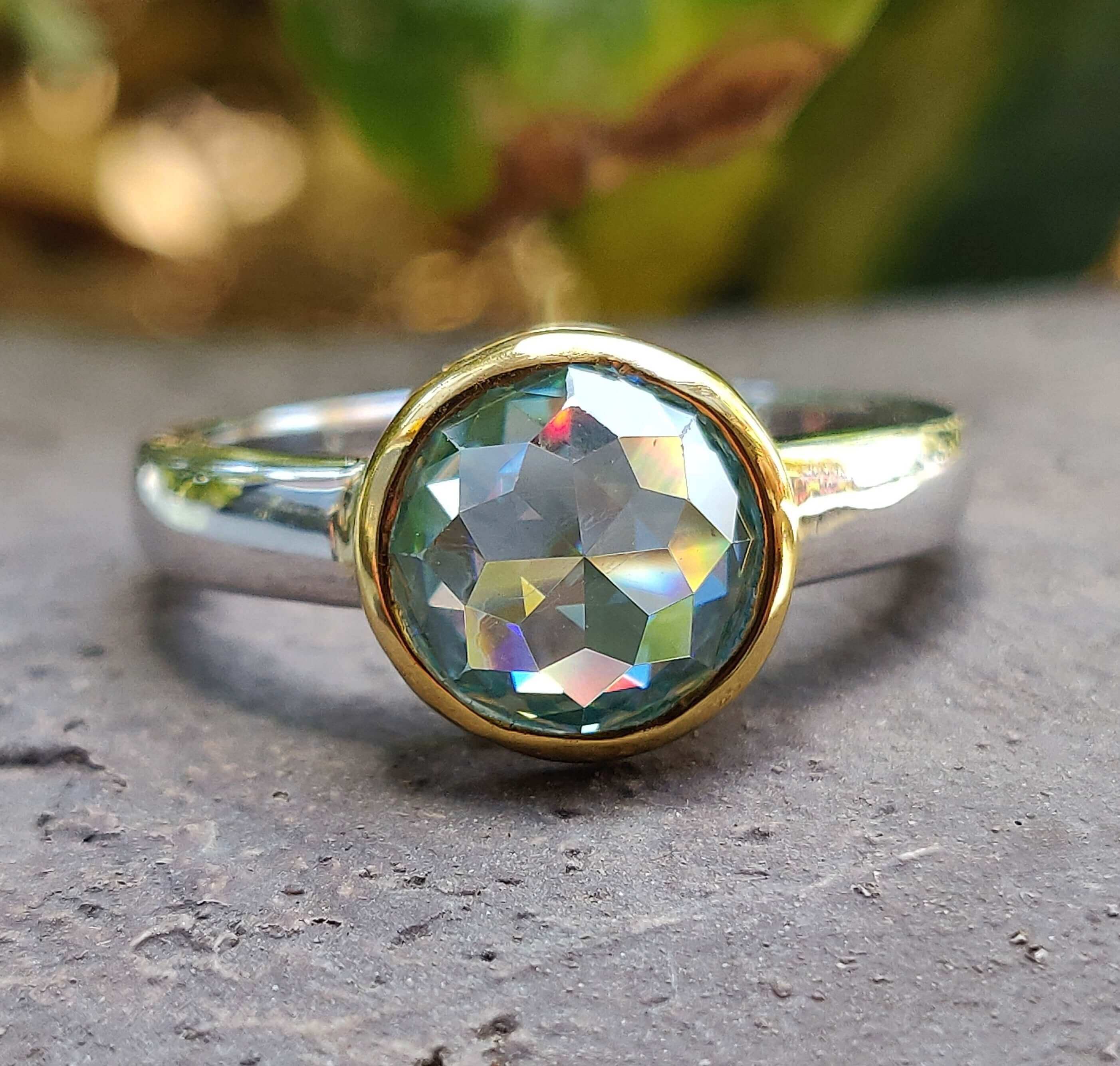 A stunning bezel setting engagement ring featuring a unique design that highlights the central stone.
