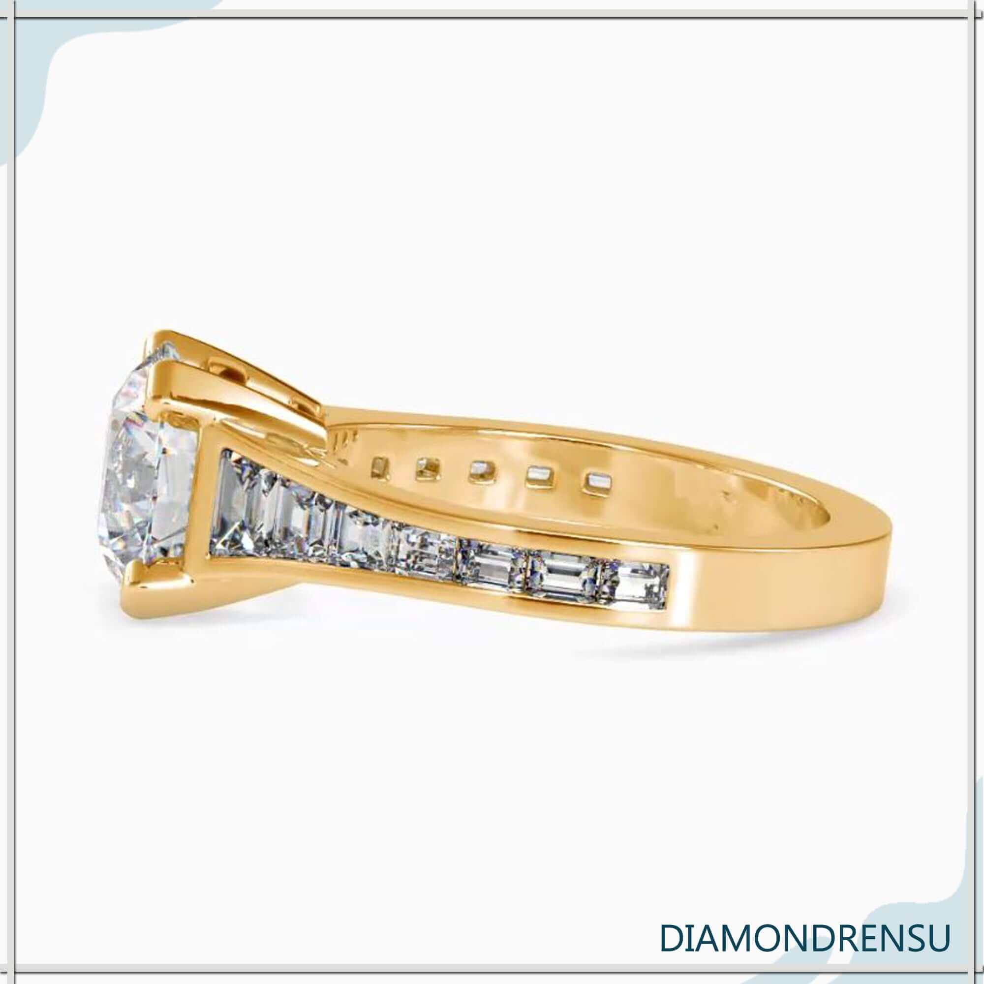 Elegant round diamond ring featuring a channel setting and tapered pave accents.