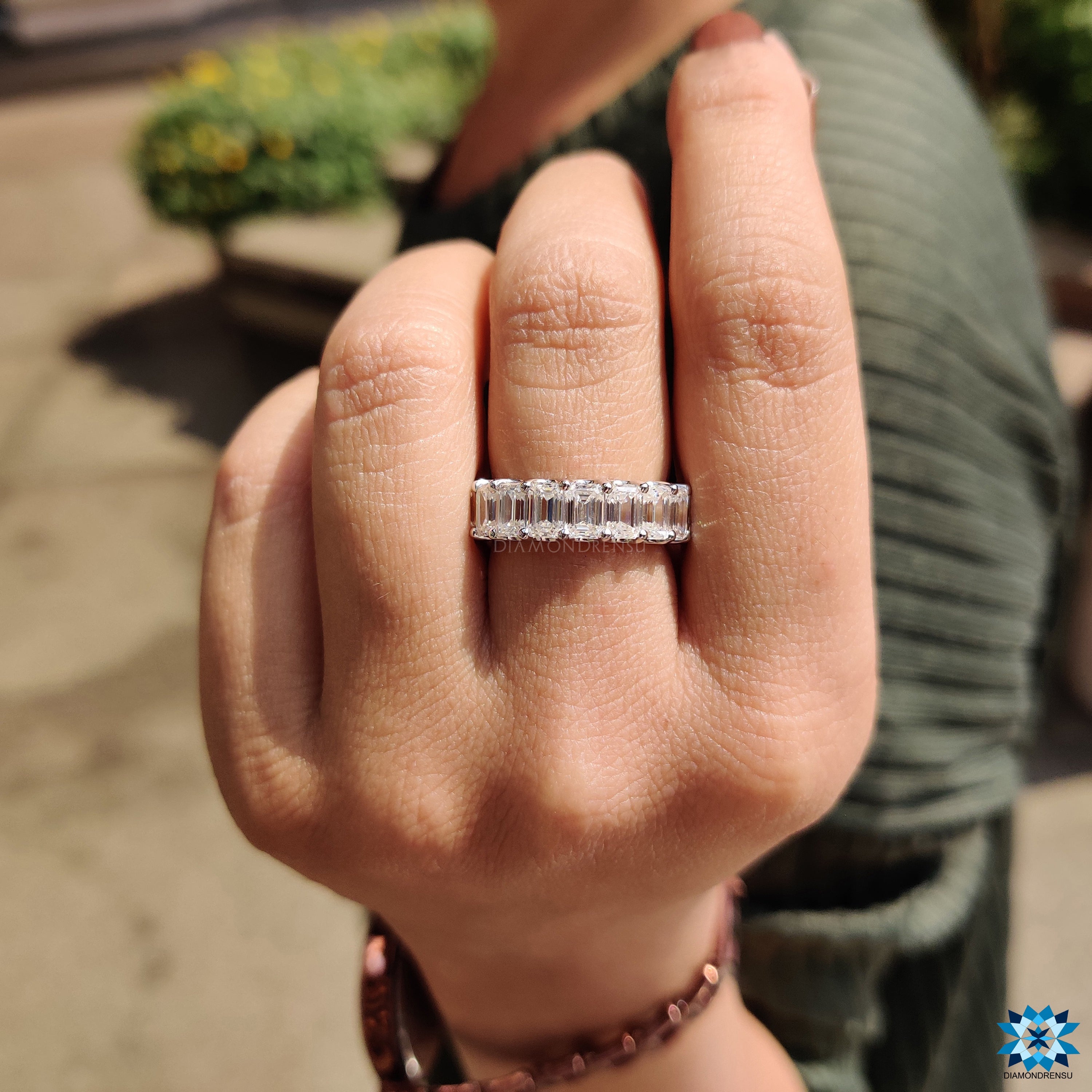 Luxurious full eternity band with emerald cuts and round prongs for a secure and stunning look.