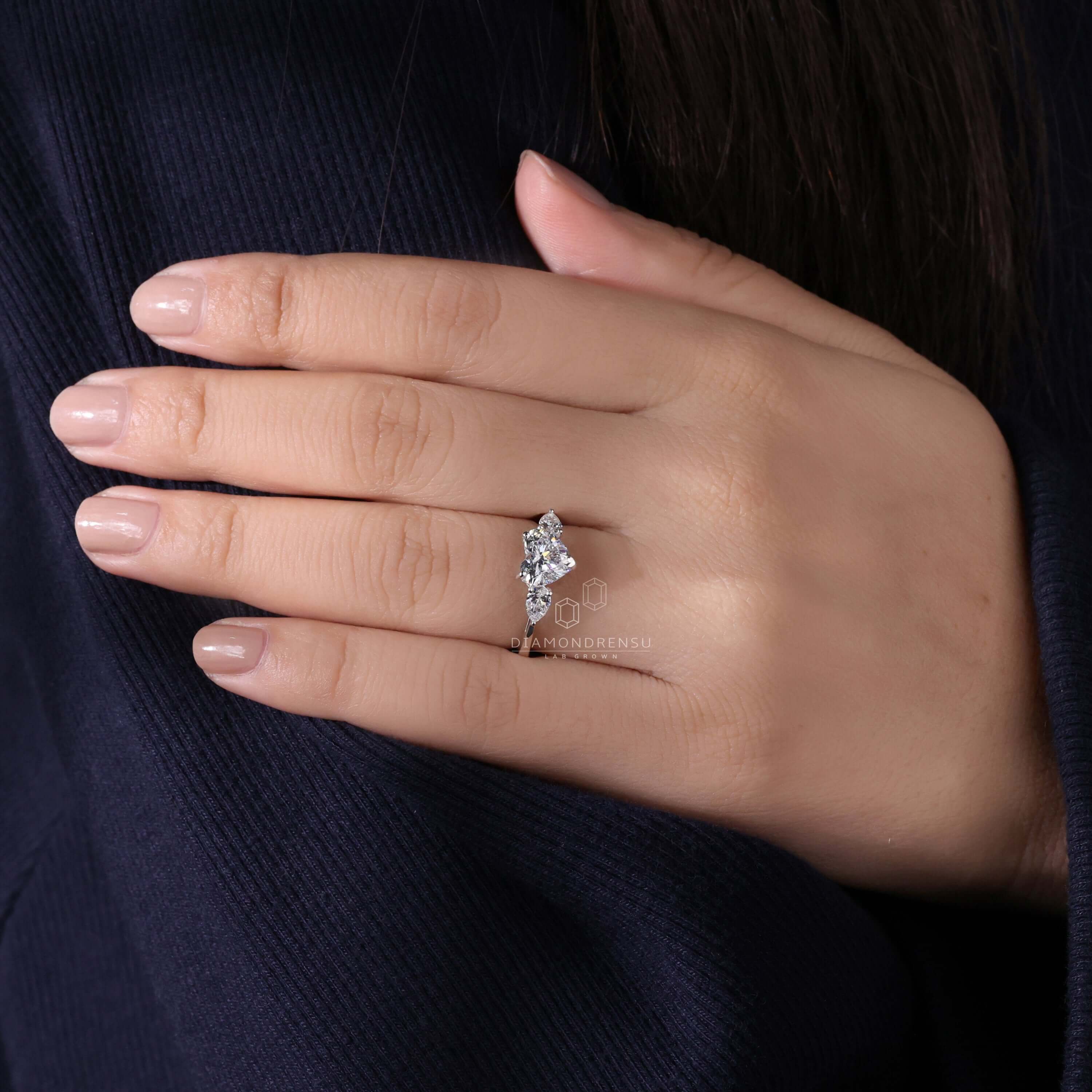 Classic three stone diamond ring on model’s finger