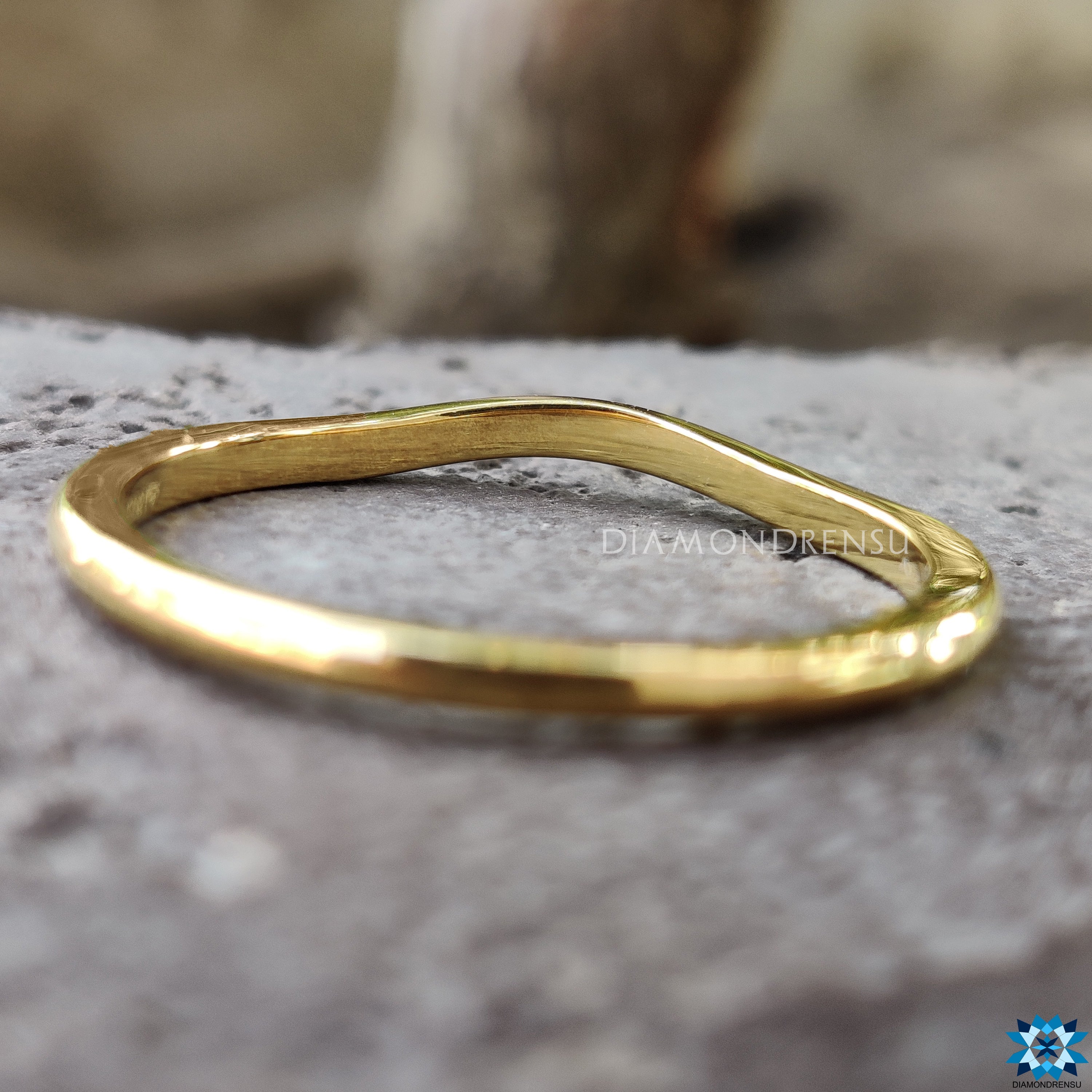 Gold curved wedding band for a modern, sophisticated look.