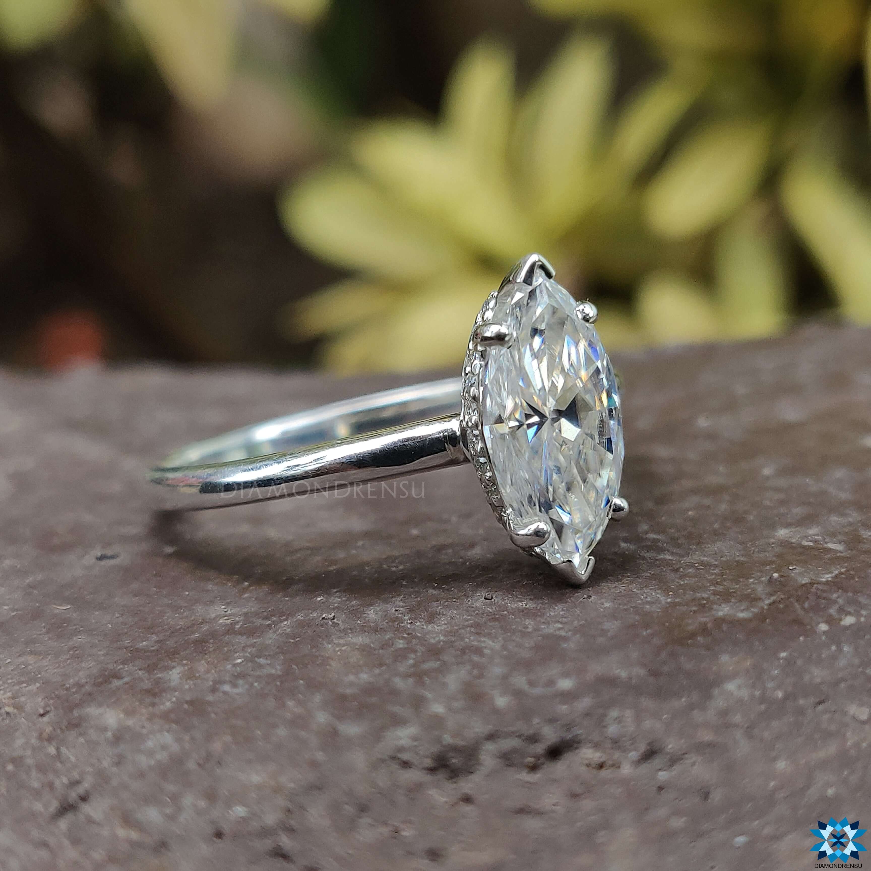 Showcasing a marquise cut moissanite engagement ring nestled in a classic 4 prong ring setting