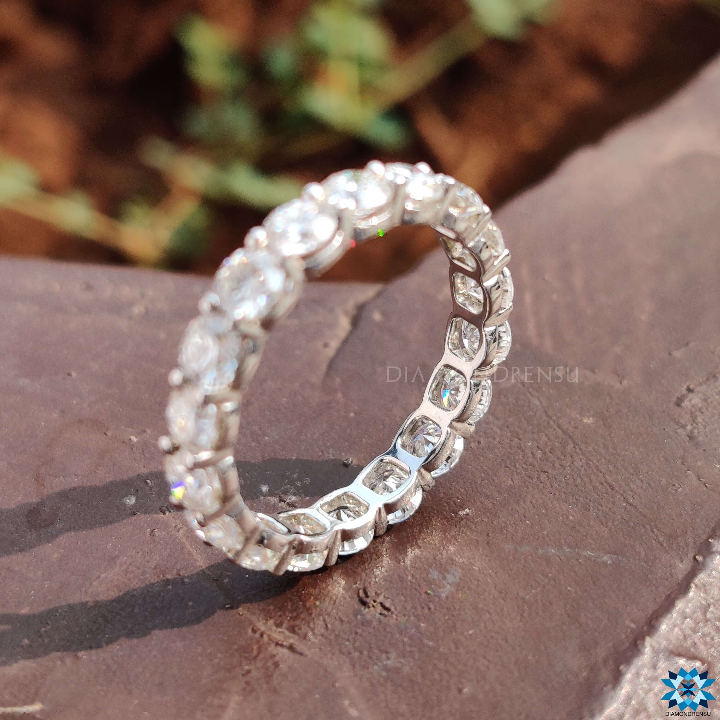 Round cut eternity band featuring brilliant stones in a handmade band design.