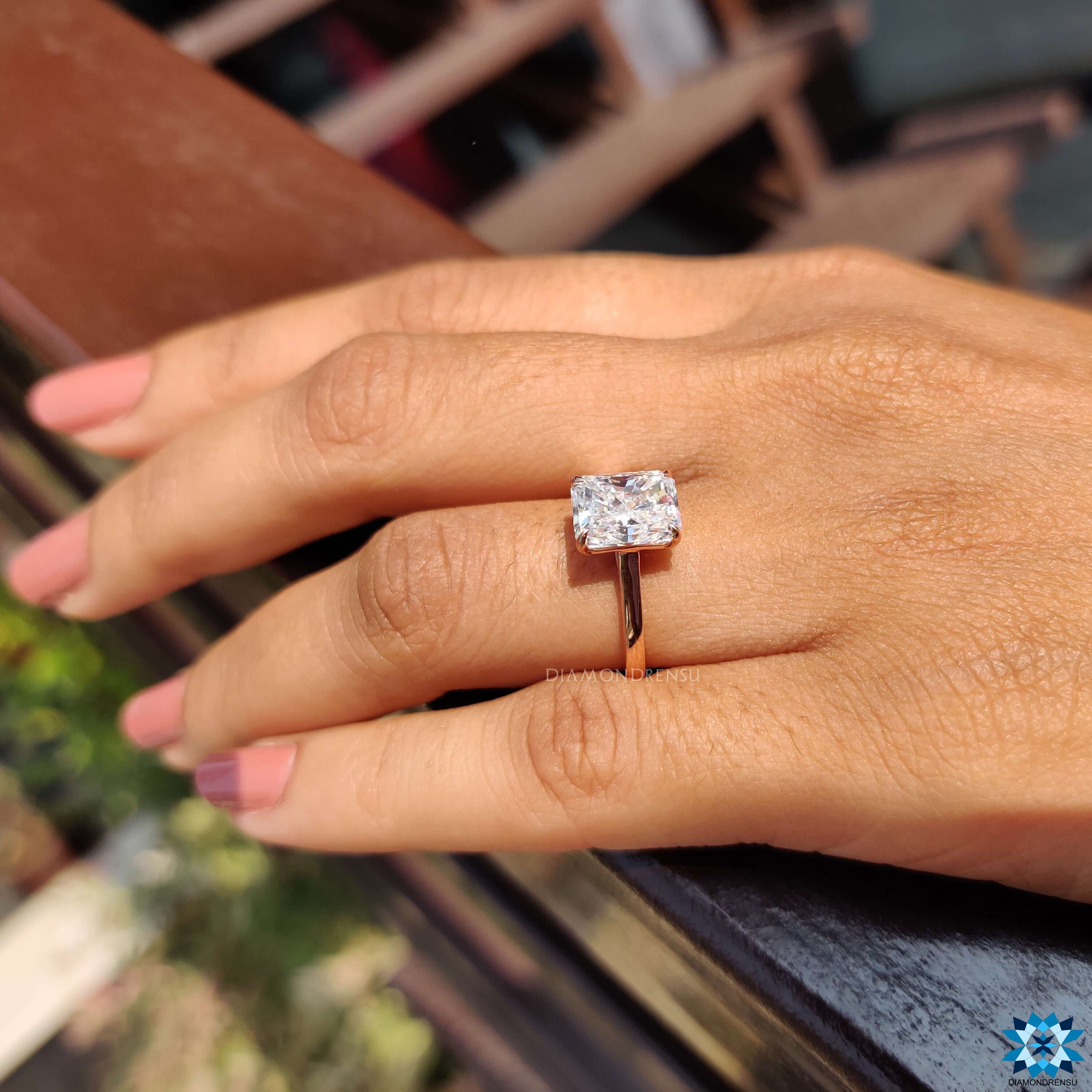 Beautiful radiant cut engagement ring with a sparkling moissanite stone, set in a sleek band.
